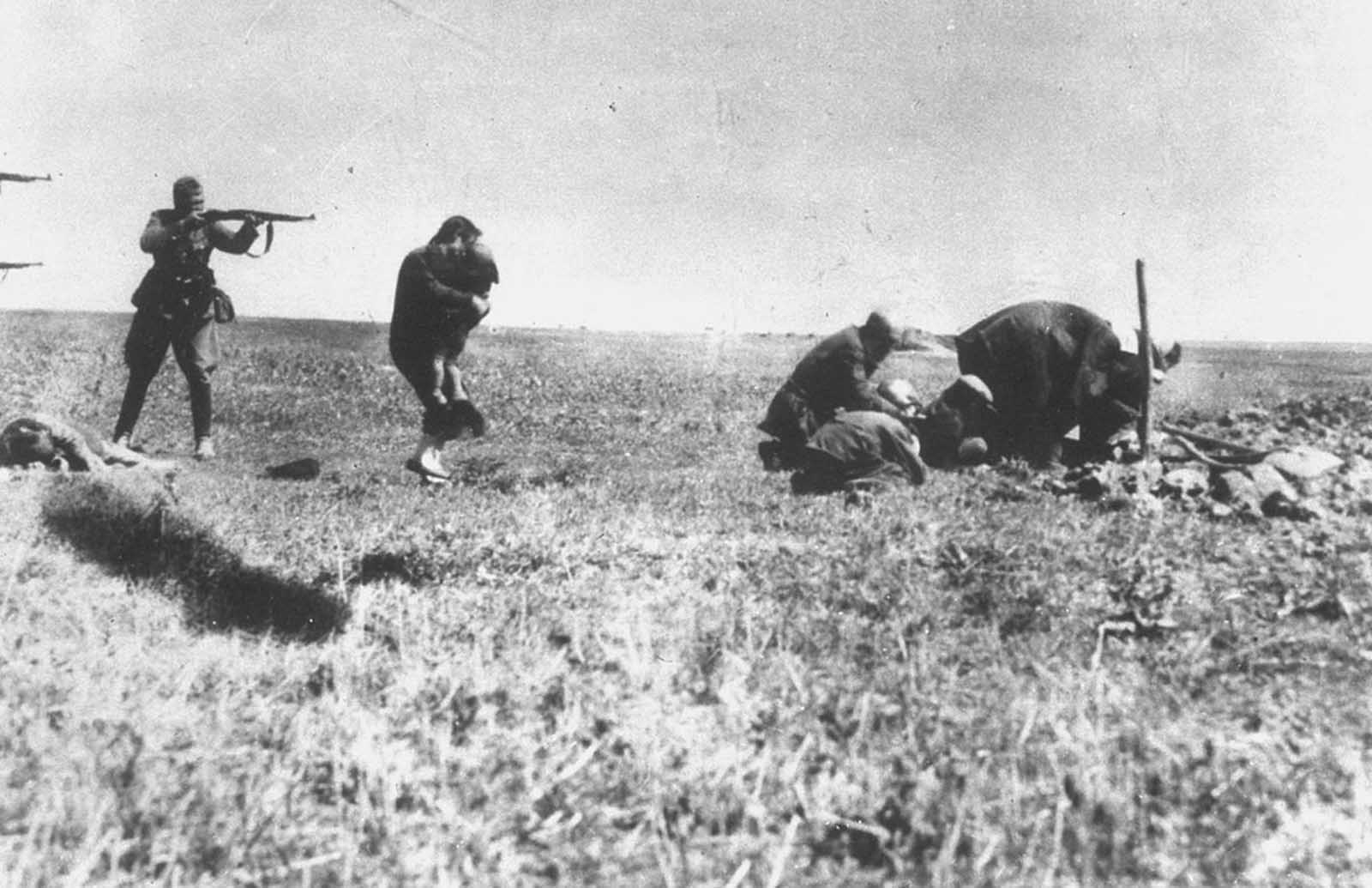 An execution of Jews in Kiev, carried out by German soldiers near Ivangorod, Ukraine, sometime in 1942. This photo was mailed from the Eastern Front to Germany and intercepted at a Warsaw post office by a member of the Polish resistance collecting documentation on Nazi war crimes. The original print was owned by Tadeusz Mazur and Jerzy Tomaszewski and now resides in Historical Archives in Warsaw. The original German inscription on the back of the photograph reads, 