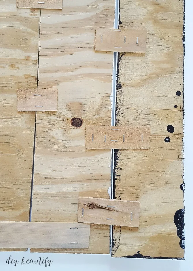 staple shims to back of sign to hold boards together