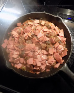 This is a skillet with fried bologna chopped and eggplant Caponata