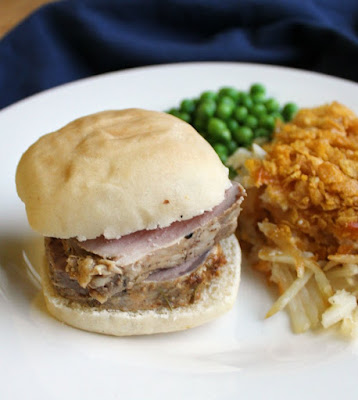 a couple of slices of pork tenderloin piled on a slider bun