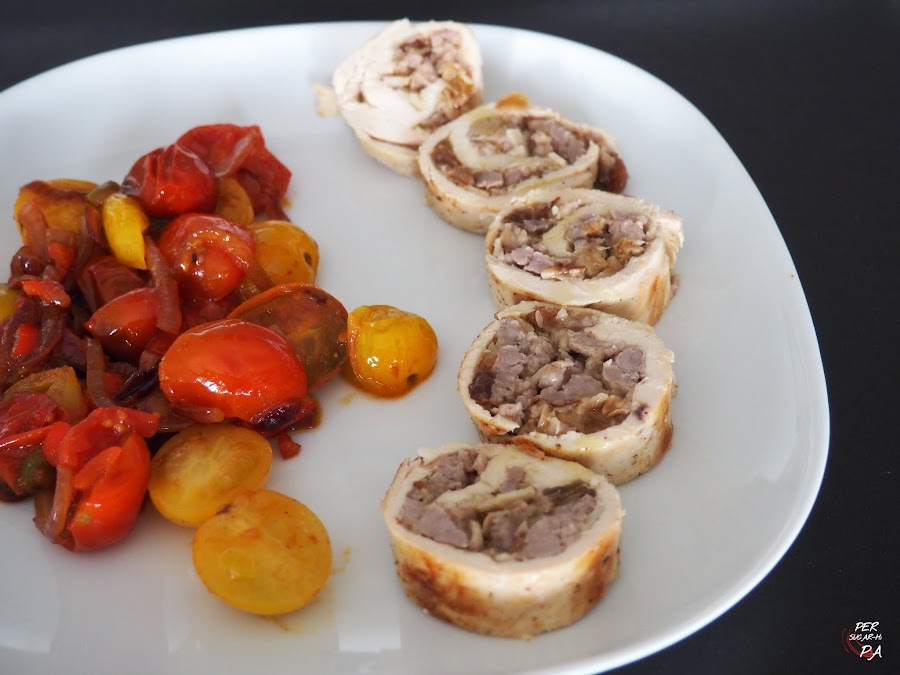 Rollitos de pechuga de pollo rellenos de carne aderezada con manzana reineta, pasas, almendras y especias. Cocidos al vapor y con guarnición de tomates cherrys pochados.