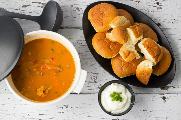Picture of a big bowl of seafood soup and additions of bread or sour creme