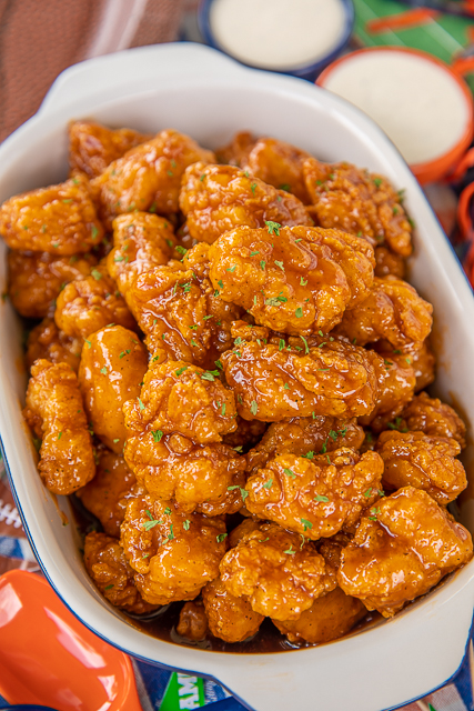 Sweet & Spicy Boneless Wings - great for parties or a quick lunch/dinner. Use frozen chicken bites and this comes together in no time!! Chicken tossed in hot sauce, brown sugar and butter. Seriously delicious!! Serve with fries and ranch or bleu cheese dressing. These are always the first thing to go at our football parties! #chicken #wings #tailgating #partyfood Sweet & Spicy Boneless Wings - great for parties or a quick lunch/dinner. Use frozen chicken bites and this comes together in no time!! Chicken tossed in hot sauce, brown sugar and butter. Seriously delicious!! Serve with fries and ranch or bleu cheese dressing. These are always the first thing to go at our football parties! #chicken #wings #tailgating #partyfood