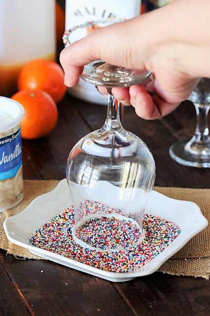 Dipping a Glass in Sprinkles for a Cake By the Ocean Cocktail Image