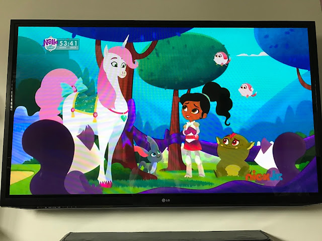 A photograph of the television showing Nella the Princess Knight Playing on NickJr. Nella and her Unicorn are both visible.