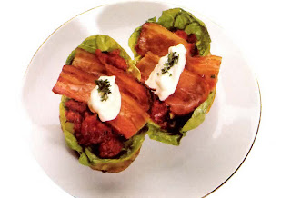 Jacket potatoes topped with tomato sauce, lettuce and bacon garnished with mayonnaise