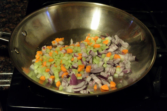The diced vegetables in the skillet, on the stove. 