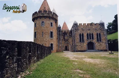 Torre de pedra construída com pedra moledo na cor meio avermelhada com espessura de 20 cm a 30 cm.