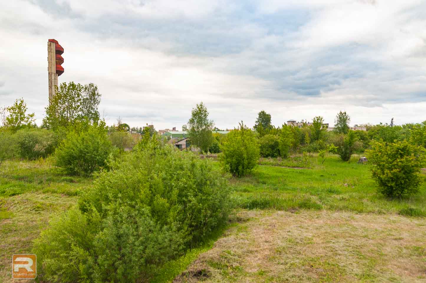 Skats no ārpuses uz aizaugušo gaļas kombināta daļu