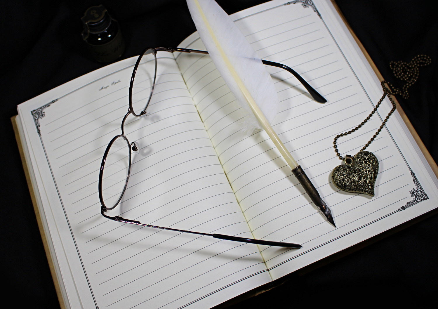 a close-up of round, retro glasses, whcih are laying on an opened diary