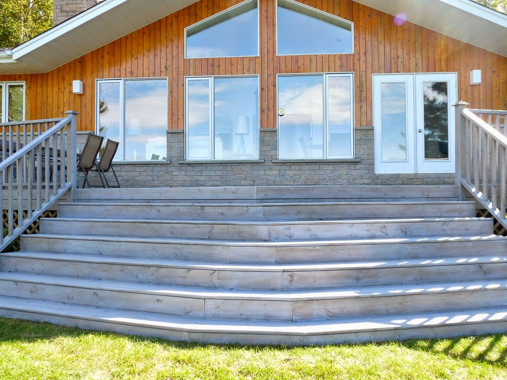Blue House With Stained Deck Blue/gray classic home with charcoal