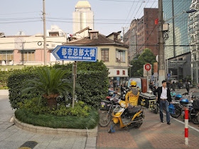 Scene along Guangdong Road including a directional sign to The Headquarters Building in Shanghai