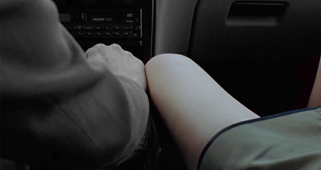 pierna de mujer rozando con mano de hombre en interior de un coche