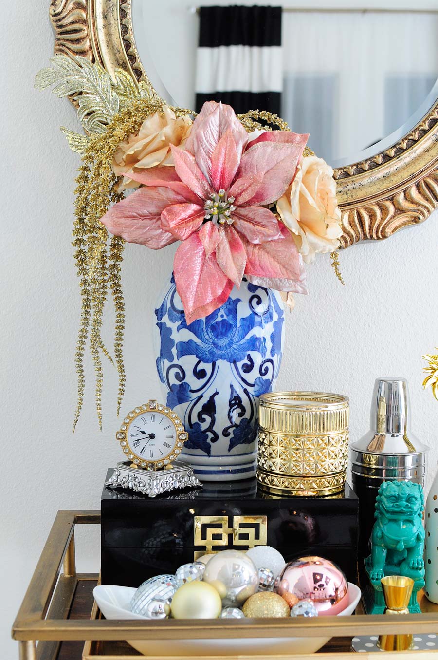 A gorgeous, eclectic bar cart decorated with blush, silver, gold and white accents, a ginger jar vase, foo dog and more. The gold mirror above the cart is perfection. A gorgeous, eclectic bar cart decorated with blush, silver, gold and white accents, a ginger jar vase, foo dog and more. The gold mirror above the cart is perfection.