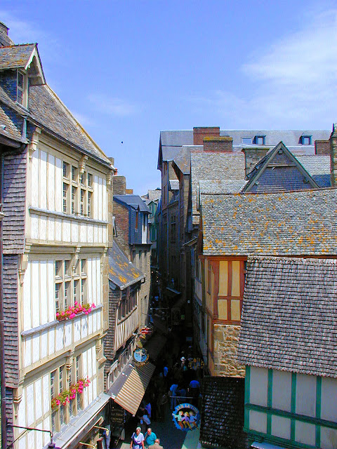 Storied half-timbered architecture lines the streets in the medieval village at the base of Mont Saint-Michel. Photo: WikiMedia.org.