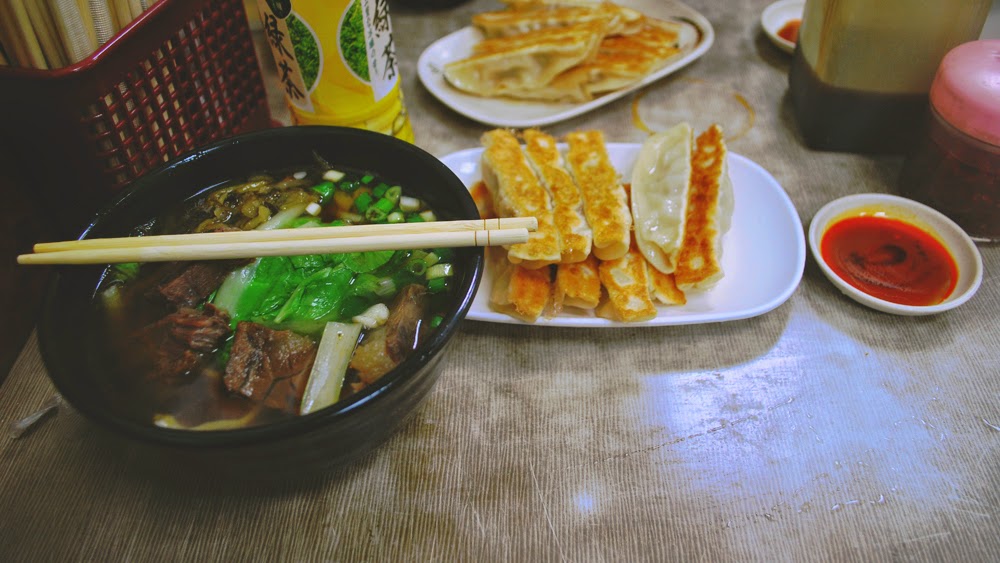 Noodle soup, sweetened green tea, potstickers, a mix of sauces.