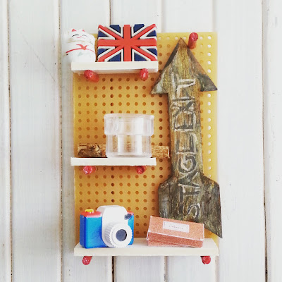 Modern one-twelfth scale miniature pegboard shelving in wood, white and red.