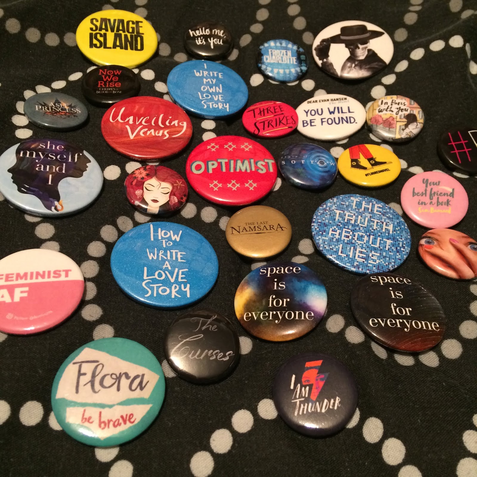 A large number of assorted badges, small and medium sized, with quotes from the books or aspects of book covers