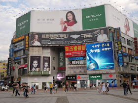 Mengzhilan M6, Oppo, and Huawei advertisements displayed at Huaxing Square in Changsha