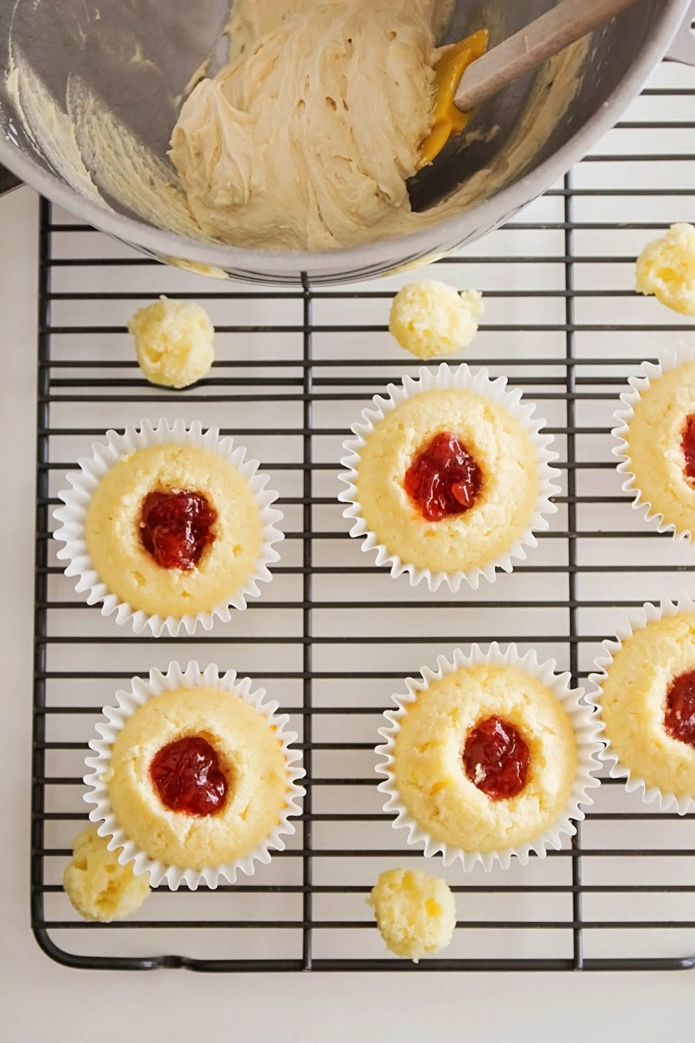 These peanut butter and jelly cupcakes are so fun and delicious! Tender white cake filled with strawberry jam and topped with a delicious peanut butter buttercream. Yum!