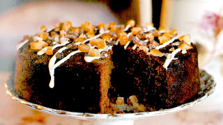 Squidgy Lemon-ginger and Apple Cake a classic dark and moist and good-keeping sponge cake served with a drizzle and sugar coffe crystals with a slice removed