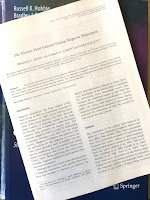 A photograph of the first page of The Electric Field Induced During Magnetic Stimulation by Roth, Cohen ad Hallett (EEG Suppl 43:268-278, 1991), superimposed on the cover of Intermediate Physics for Medicine and Biology.
