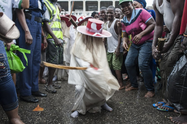 A young Eyo masquerader dances as he leads the group into the Tafawa Balewa Square in Lagos on May 20, 2017. The white-clad Eyo masquerades represent the spirits of the dead and are referred to in Yoruba as “agogoro Eyo. The origins of the Eyo Festival are found in the inner workings of the secret societies of Lagos where the masquerades ensure safe passage for the spirit of Kings and notable Chiefs into the afterlife. / AFP PHOTO / STEFAN HEUNIS