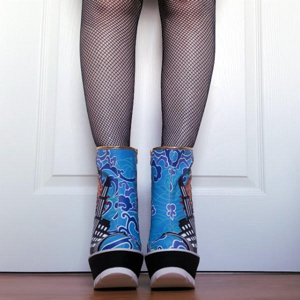 Irregular Choice Jurassotops front front view of blue patterned ankle boots on legs wearing fishnet tights