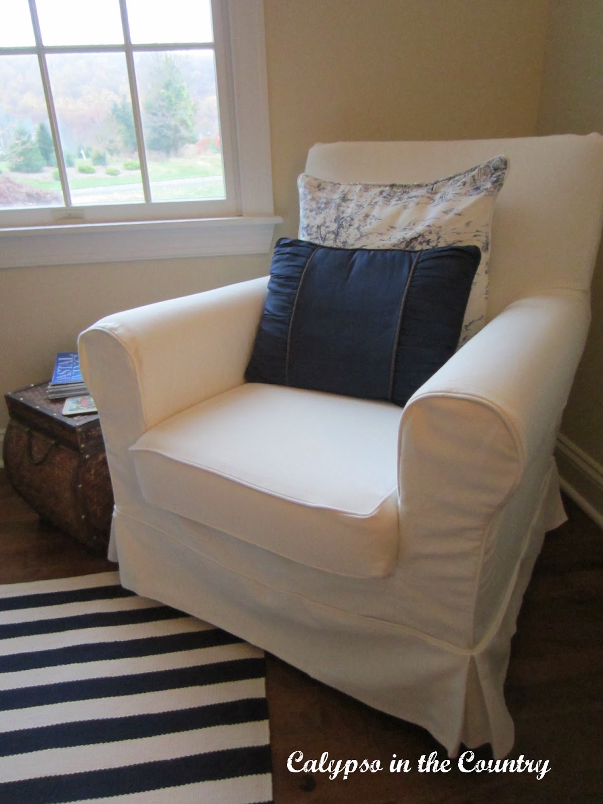 White Slipcovered chair with blue pillows