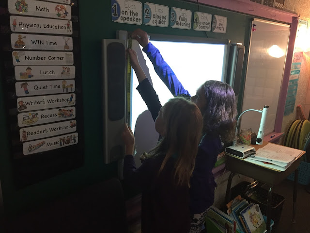 two kids measuring smart board
