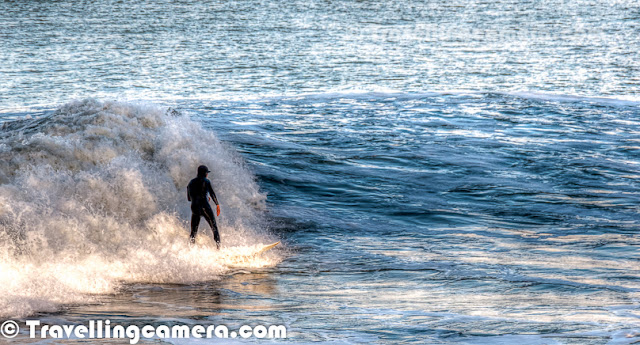 Photo Walk around San Francisco was one of the highlight of my recent trip to US and our last spot during the PHOTO WALK was Surfing point under Golden Bridge. This Photo Journey shares some of the moments captured under Golden Bridge of San Francisco. Surfing is a surface water sport in which the wave rider, 'surfer', rides on the forward face of a wave. Waves suitable for surfing are found primarily in the ocean, but can be found in some lakes, in rivers in the form of a standing wave. Surfing can also be done in artificial water sources such as wave pools and boat wakes. The term 'surfing' refers to the act of riding a wave and not the form in which the wave is ridden After having lunch at De Young Museum, we moved to the bottom of Golden Bridge where lot of surfers were getting ready for surfing in Pacific Ocean. They were carrying surfing boards in their cars and changing the cloths to gear up for a great adventure in water. Most of the these photographs are cropped versions, as they were surfing at a significant distance from shoreline.  This is first time that I saw people doing surfing in front of me and even when chilled wind was blowing all around the San Francisco town. It was a cloudy day and most of us were wearing multi-layered cloths. After coming back from this point, I realized that I should have made a video of these folks surfing in the ocean as action is not well captured in these photographs. It's really amazing to see surfers playing so well with high waves in ocean.Surfing can be done on various equipments including surfboards, longboards, Stand Up Paddle boards (SUP's), bodyboards, wave skis, skimboards, kneeboards, surf mats and macca's trays. Surfers of different age groups were there at Golden Bridge to enjoy the day... After mild rains in the morning, sun was out.Three major subdivisions within sitting-up surfing are longboarding, shortboarding, and stand up paddle surfing (SUP), reflecting differences in board design, including surfboard length, riding style and the kind of wave that is ridden.Surfers represent a diverse culture based on riding the waves. Some people practice surfing as a recreational activity while others make it the central focus of their lives. Within the United States, surfing culture is most dominant in Hawaii and California because these two states offer the best surfing conditions. Some historical markers of the culture included the woodie, the station wagon used to carry surfers' boards, as well as boardshorts, the long swim shorts typically worn while surfing.Several of San Francisco's parks and nearly all of its beaches form part of the regional Golden Gate National Recreation Area, one of the most visited units of the National Park system in the United States with over 13 million visitors a year. Among the GGNRA's attractions within the city are Ocean Beach, which runs along the Pacific Ocean shoreline and is frequented by a vibrant surfing community.