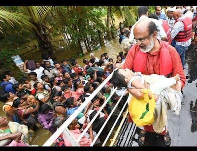 Minister Thomas Issac carrying a baby during the flood rescue mission in kuttanadu Kerala
