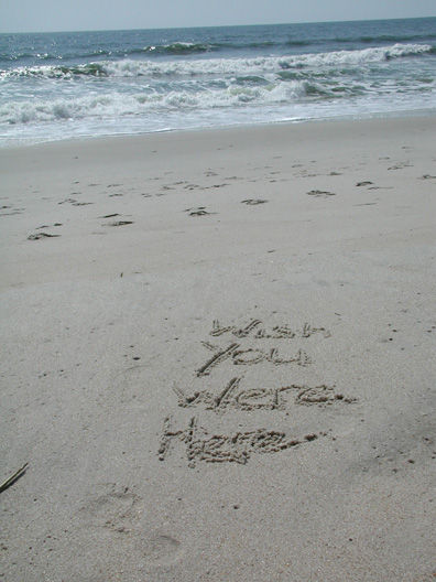 I wish you were here written in beach sand