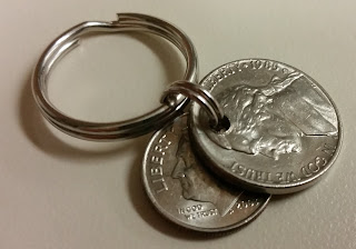 A nickel and dime on a key ring.