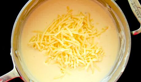Lekkere kaassaus maken op basis van een witte roux van bloem en boter, verwerkt tot bechamelsaus met volle melk en afgewerkt met kruiden en 2 soorten geraspte kaas