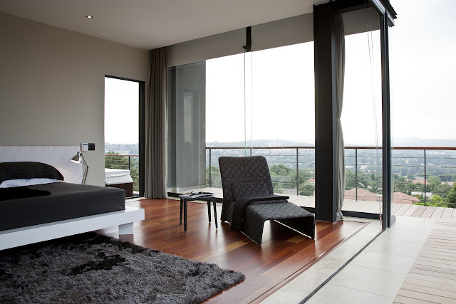 Picture of black and white furniture in the bedroom with glass walls 