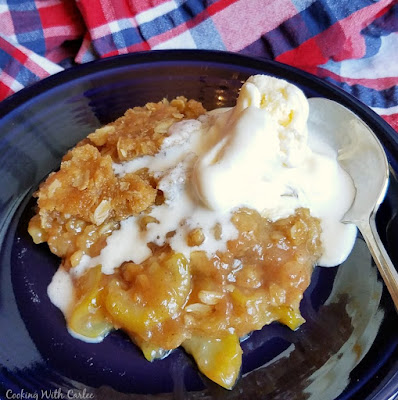 This fun recipe turns summer zucchini into a delicious dessert! The brown sugar crisp tastes so good and it's just like eating an apple crisp. Top with vanilla ice cream for a perfect summer treat! plate of zucchini crisp with melted ice cream scoop on top