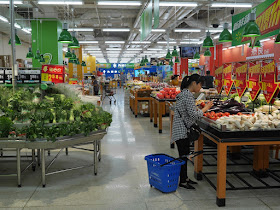 woman choosing tomatoes at a Walmart in Zhongshan, China