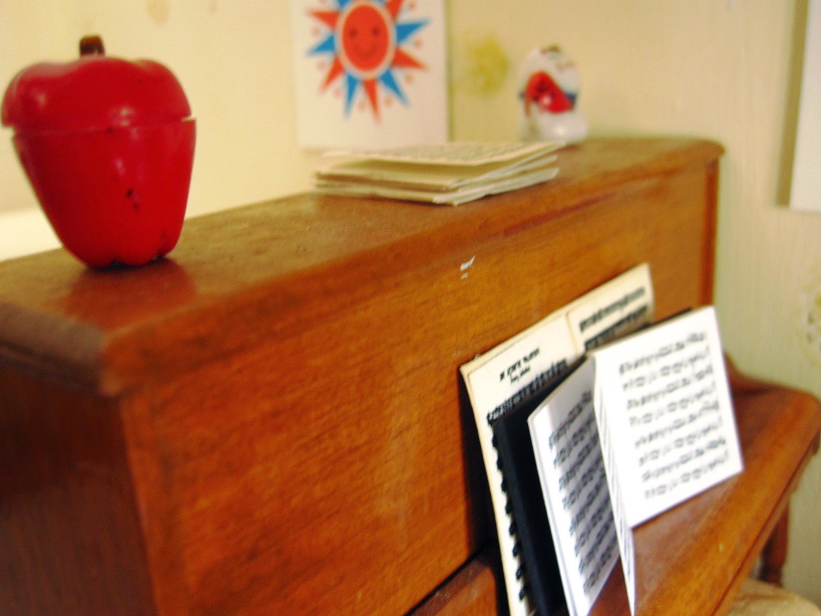 Modern dolls' house miniature piano with sheet music.