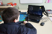 Imagem de um aluno c/nee a trabalhar com táblete e PC