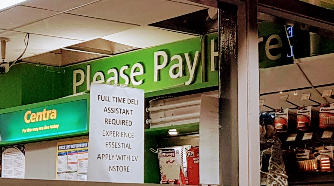 Please Pay Here sign above the checkout in an Irish corner store