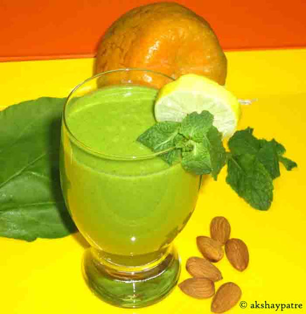 Orange spinach mint almond flax seeds smoothie in a serving glass