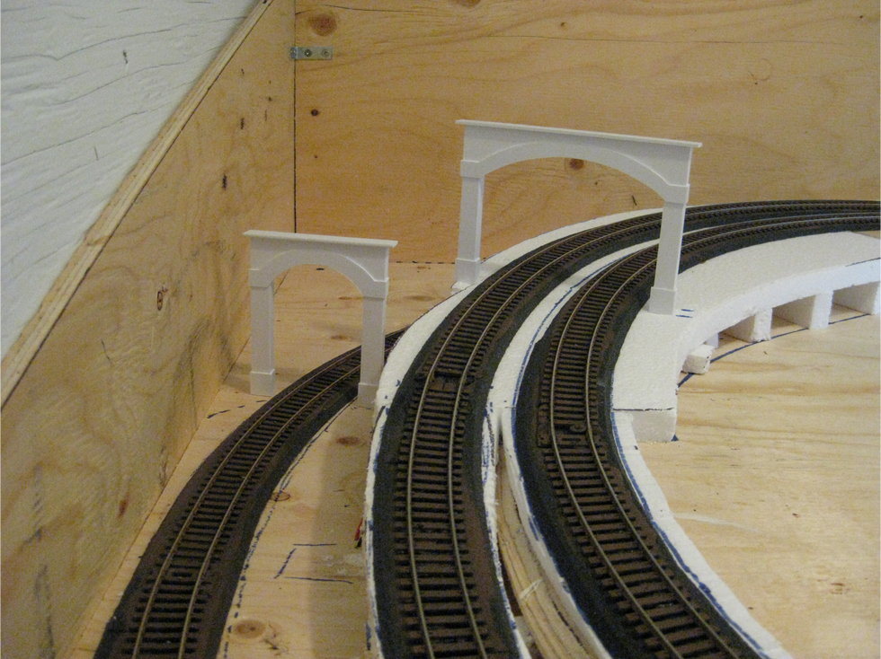 A single and double styrene tunnel portal placed on model railroad track to test fit