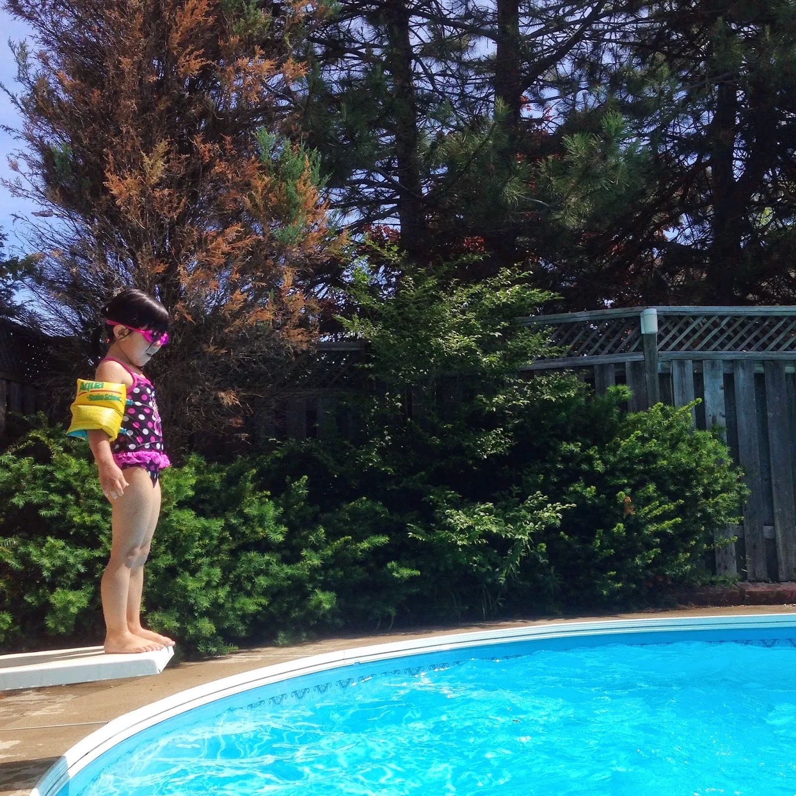 girl jumping diving board swimming pool summer