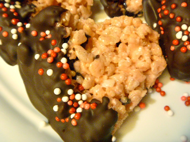 Valentine heart rice krispie treats studded with cherries and strawberry flavor dipped in chocolate take this over the top for a Valentine snack! - slice of southern