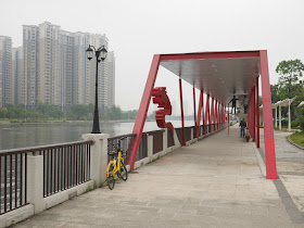 men painting a riverside covered walkway sculpture at the Dragon Boat Cultural Park (龙舟文化公园)