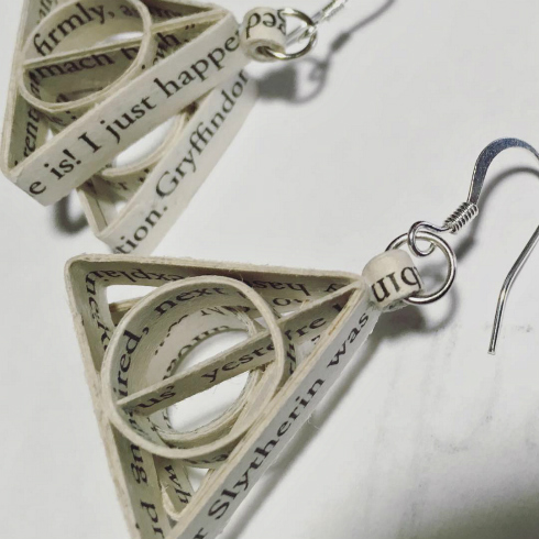 Triangular earrings composed of shaped strips of Harry Potter book page text 