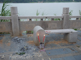 two traditional Chinese red candles burning in a can next to the river