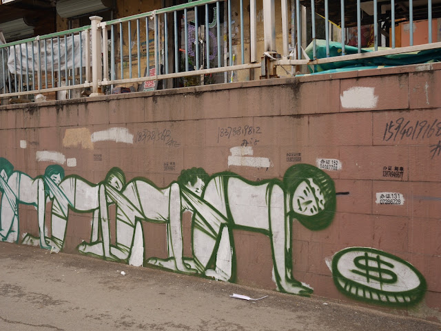 people crawling behind one another with their face tied to the rear end of the person in front of them and a large coin at the front