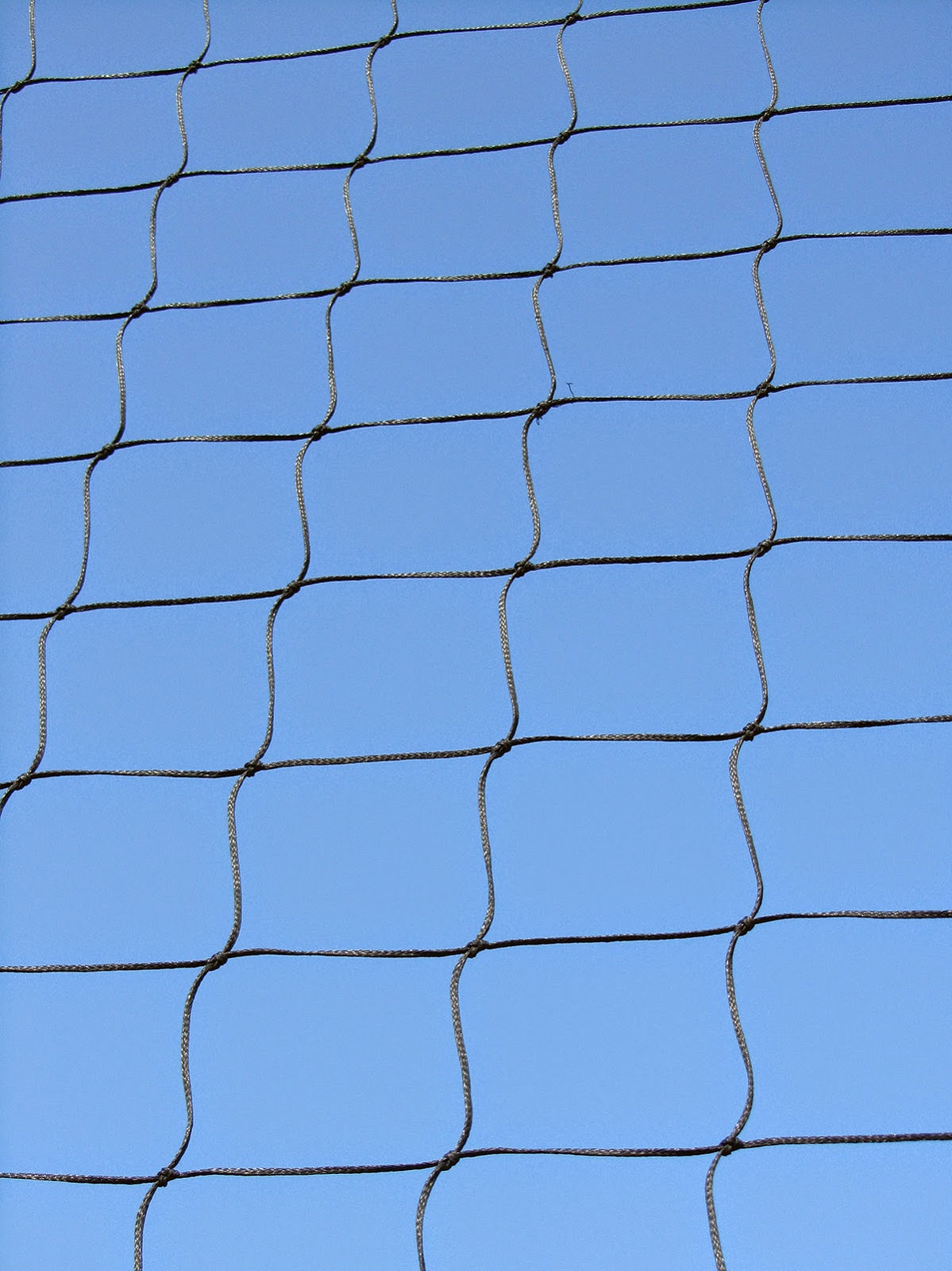 pattern of a soccer net against a blue sky